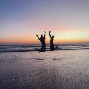 Two women jumping on the beach at sunset in Tamarindo