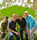 a family underneath a giant leaf during a hike in Costa Rica