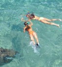 two women snorkeling in clear blue ocean on a custom vacation in Costa Rica