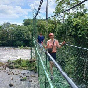 Family hiking a hanging bridge over a river in Costa Rica