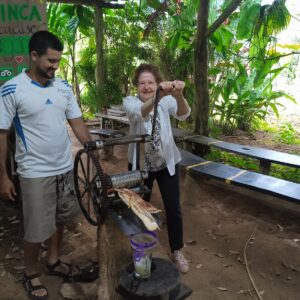 Senior traveler using a sugar cane trapiche in Costa Rica