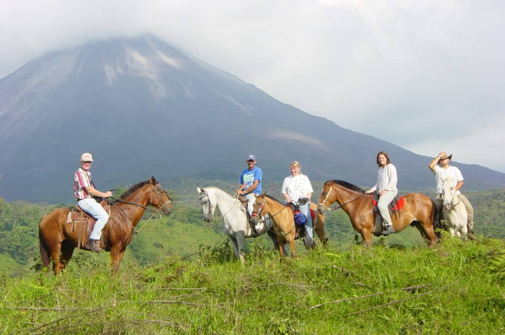 five travellers horseback riding around the Arenal Volcano in Costa Rica