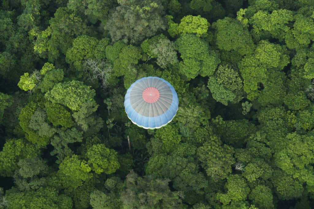 a birds-eye view of a hot air balloon flying over rainforest in Costa Rica